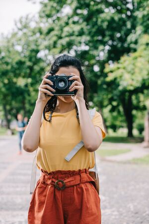 woman covering face while taking photo on digital cameraの写真素材