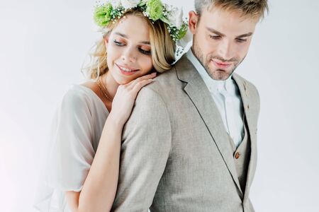 attractive bride and handsome bridegroom smiling and looking awayの写真素材