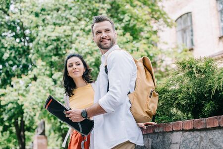 happy bearded man holding map near attractive womanの写真素材