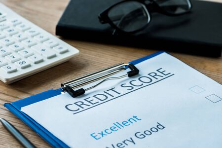 selective focus of paper with credit score lettering near glasses