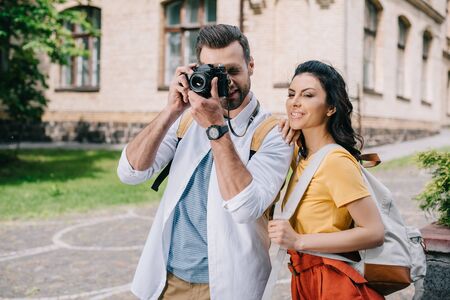 bearded man covering face while taking photo near womanの写真素材