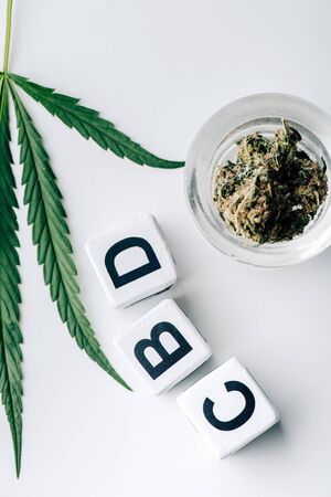 top view of cubes with lettering cbd, medical cannabis and marijuana on white background