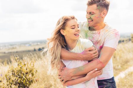 attractive woman and handsome man smiling and hugging outside