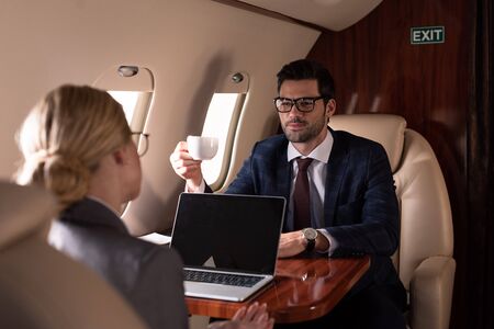 executive professional businesspeople having meeting with laptop in plane