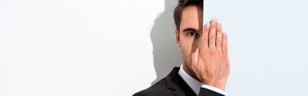 panoramic shot of man looking at camera on whiteの写真素材