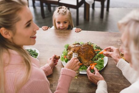 selective focus of cute kid looking at tasty turkey in Thanksgiving dayの写真素材