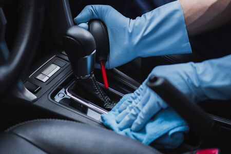 cropped view of car cleaner dusting gear shifter with rubber air lower and ragの写真素材