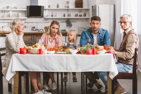 caucasian family members sitting at table in Thanksgiving day