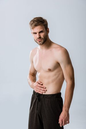 shirtless sportman with abdominal pain isolated on greyの写真素材