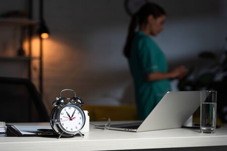 selective focus of alarm watch, glass and laptopの写真素材