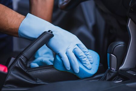 cropped view of car cleaner wiping car seat with spongeの写真素材