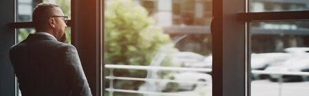 panoramic shot of businessman in formal wear talking on smartphone