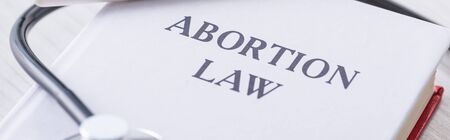 panoramic shot of book with abortion law lettering near stethoscope  の写真素材