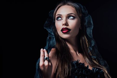 scary vampire girl in black gothic dress and veil isolated on blackの写真素材