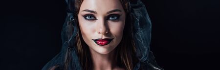 panoramic shot of scary vampire girl in black gothic dress and veil isolated on black