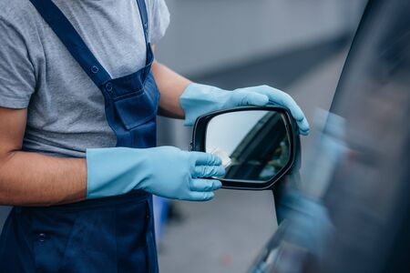 cropped view of car cleaner wiping side mirror of carの写真素材