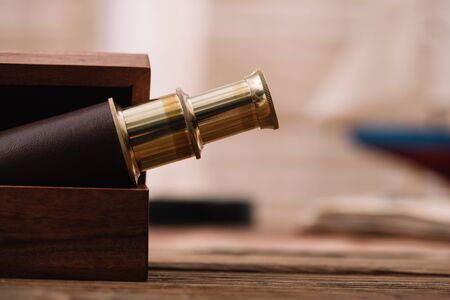 brown and golden telescope in open wooden box