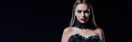panoramic shot of scary vampire girl in black gothic dress isolated on blackの写真素材