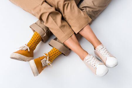 cropped view of man and woman sitting on white