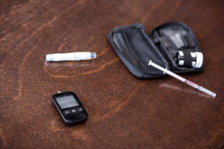 selective focus of glucose monitor near blood lancer on tableの写真素材