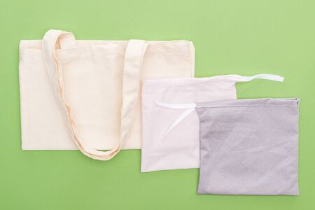 top view of empty cotton eco bags isolated on greenの写真素材