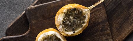 top view of sweet granadilla on wooden cutting boards on grey background, panoramic shot