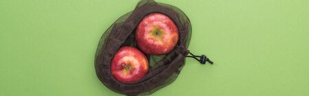 top view of red ripe apples in eco friendly bag isolated on green, panoramic shotの写真素材