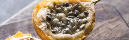 close up view of sweet granadilla on wooden cutting boards on grey background, panoramic shotの写真素材