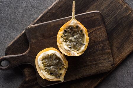 top view of sweet granadilla on wooden cutting boards on grey backgroundの写真素材