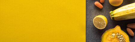 top view of fruits and vegetables on yellow and grey background, panoramic shotの写真素材