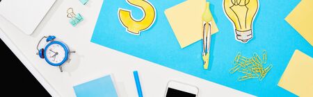 top view of workplace with office supplies on blue and white backgroundの写真素材