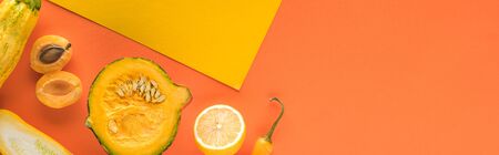 top view of yellow fruits and vegetables on orange background with copy space, panoramic shotの写真素材