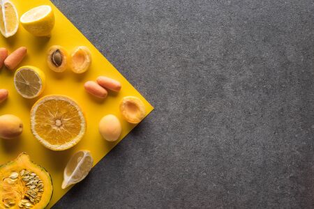 top view of fruits and vegetables on yellow and grey backgroundの写真素材