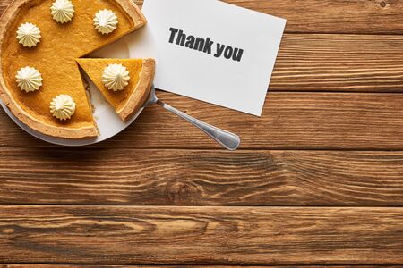 top view of tasty pumpkin pie and thank you card on wooden rustic tableの写真素材