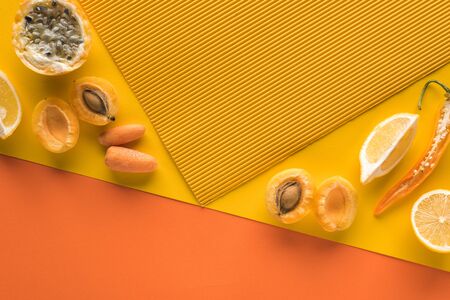 top view of fresh fruits and vegetables on yellow and orange background with copy space