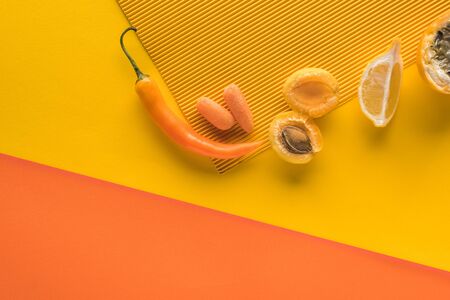 top view of fresh fruits and vegetables on yellow and orange background with copy space