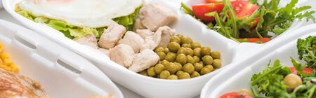 panoramic shot of eco package with green peas, meat and salad on white backgroundの写真素材