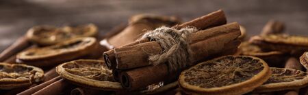 close up view of dried orange slices and cinnamon bunch, panoramic shot