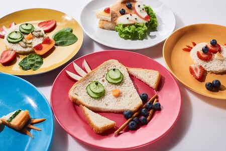 plates with fancy animals made of food for childrens breakfast on white backgroundの写真素材