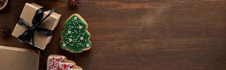 top view of Christmas tree cookies near gift box on wooden table, panoramic shot, panoramic shotの写真素材