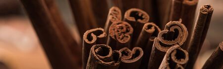 close up view of aromatic fresh cinnamon sticks, panoramic shot