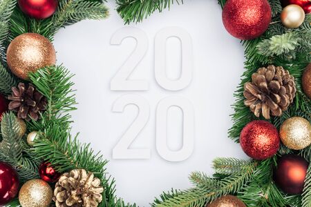 top view of 2020 numbers in Christmas tree wreath on white background