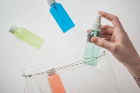 cropped view of woman holding bottle with liquid on white backgroundの写真素材