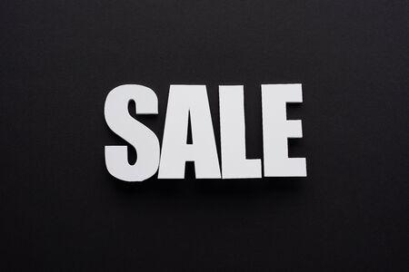top view of white sale lettering on black background