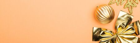 top view of golden Christmas decoration on orange background with copy space, panoramic shotの写真素材