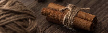 selective focus of ball of thread and cinnamon sticks on wooden surface, panoramic shotの写真素材