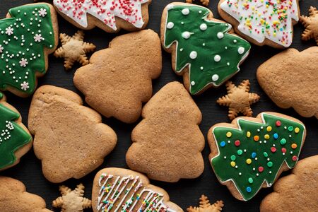 delicious glazed Christmas cookies on black background