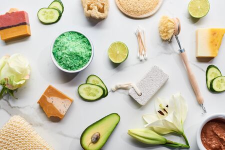 top view of natural beauty products and gadgets and soap pieces near fresh flowers, vegetables and fruit on marble surfaceの写真素材
