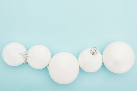 top view of white Christmas balls on light blue background with copy spaceの写真素材