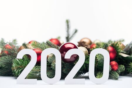 paper 2020 numbers near Christmas tree wreath with baubles isolated on whiteの写真素材